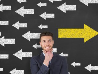 Man standing in front of directional arrows pointing left and right